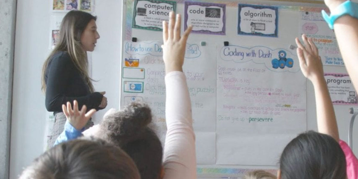 A teacher teaching coding in a elementary school classroom